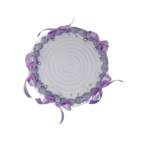 Decorative round pillow with purple ribbons and pearls on a white background
